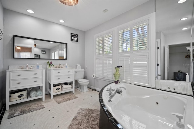 full bathroom with baseboards, toilet, a whirlpool tub, recessed lighting, and vanity