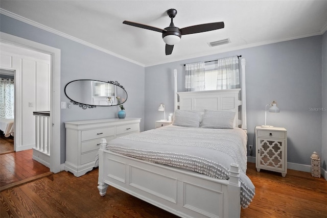 bedroom with dark wood-style floors, baseboards, visible vents, ceiling fan, and ornamental molding