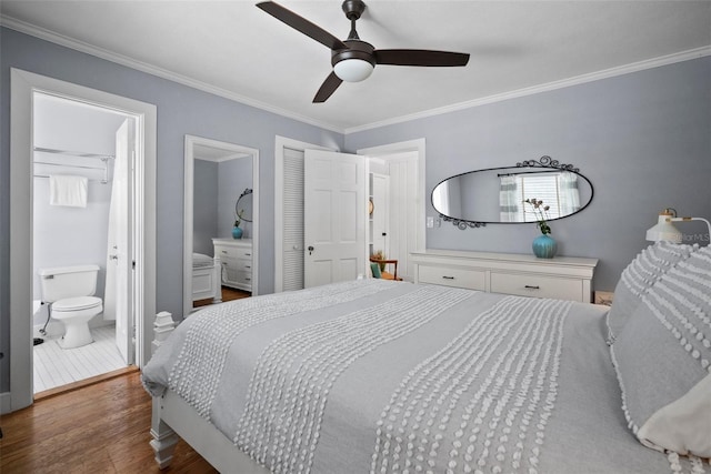 bedroom with ceiling fan, connected bathroom, wood finished floors, and ornamental molding