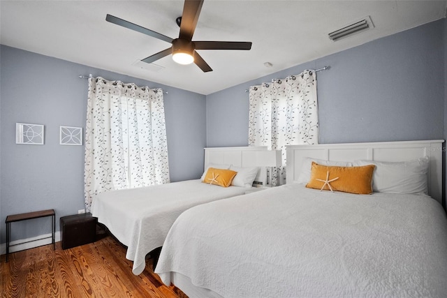 bedroom with wood finished floors, visible vents, and ceiling fan