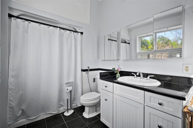 full bathroom featuring vanity, wainscoting, tile patterned floors, toilet, and tile walls