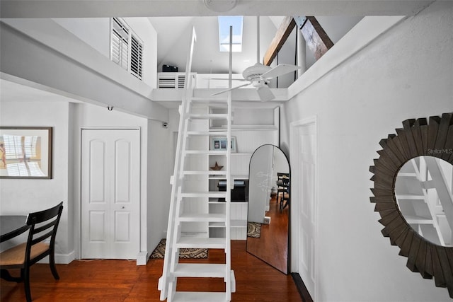 walk in closet with a towering ceiling, ceiling fan, and wood finished floors