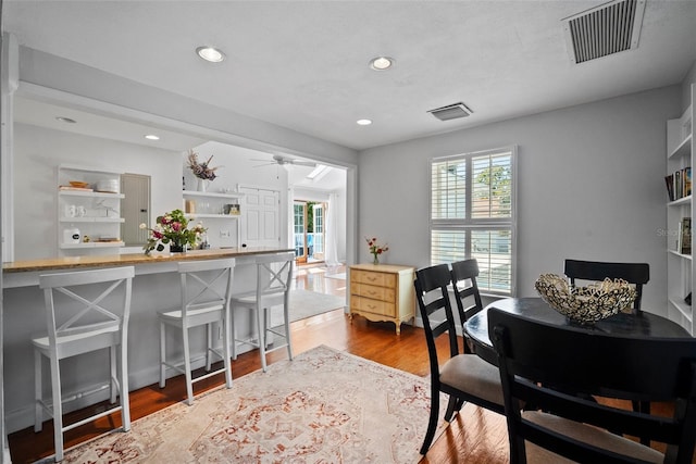 dining space featuring wood finished floors, visible vents, a wealth of natural light, and ceiling fan