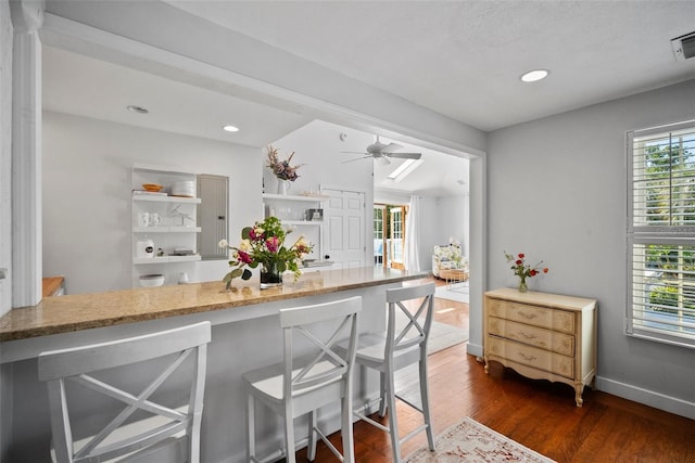 kitchen featuring light stone counters, a ceiling fan, baseboards, recessed lighting, and dark wood-style flooring