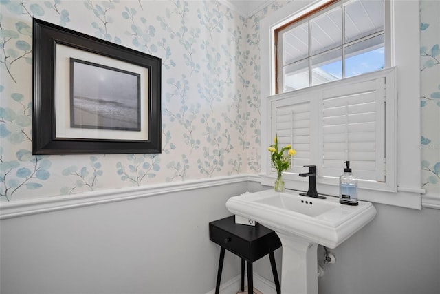 bathroom featuring wainscoting and wallpapered walls