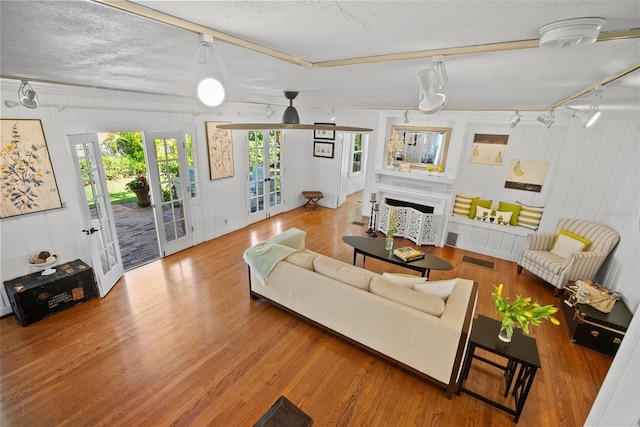 living room featuring visible vents, french doors, a textured ceiling, and wood finished floors