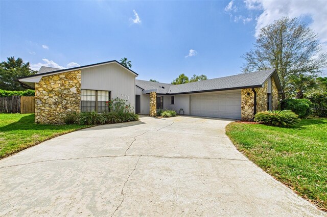 1776 E Cheryl Dr, Winter Park, FL 32792 - mid-century modern home with stone siding, a garage, and driveway