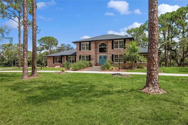 view of front of house with brick siding and a front yard