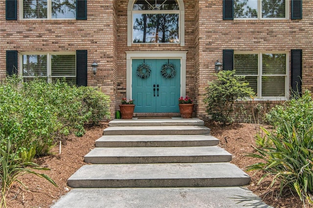 view of exterior entry with brick siding