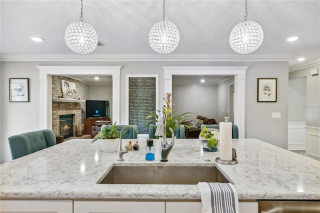 kitchen with hanging light fixtures, open floor plan, and a sink