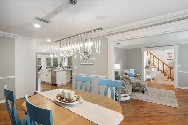 dining area featuring visible vents, wood finished floors, recessed lighting, crown molding, and stairs