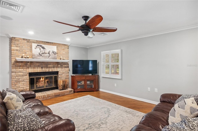 living room featuring visible vents, baseboards, ceiling fan, ornamental molding, and wood finished floors