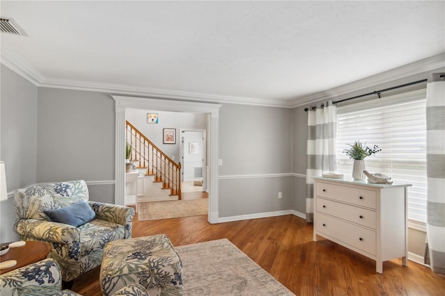 sitting room with visible vents, ornamental molding, wood finished floors, stairway, and baseboards