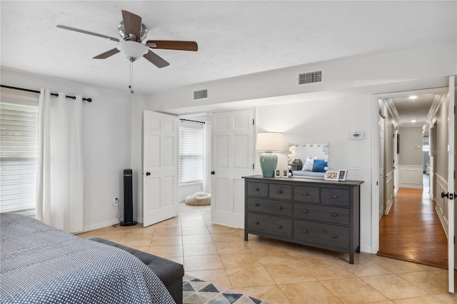 bedroom featuring light tile patterned floors, visible vents, and ceiling fan