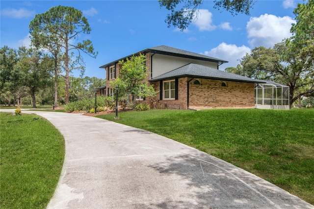 view of home's exterior with a lawn, roof with shingles, concrete driveway, and brick siding