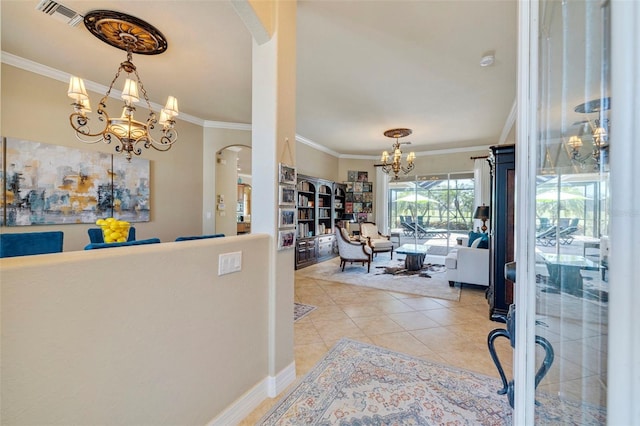 entrance foyer featuring visible vents, arched walkways, ornamental molding, and a chandelier