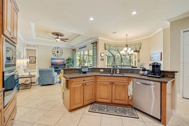 kitchen featuring crown molding, appliances with stainless steel finishes, a sink, open floor plan, and light tile patterned floors