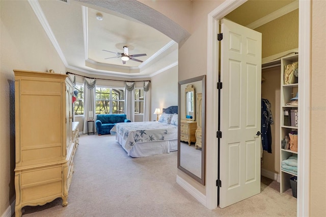 bedroom with baseboards, a raised ceiling, crown molding, and light carpet