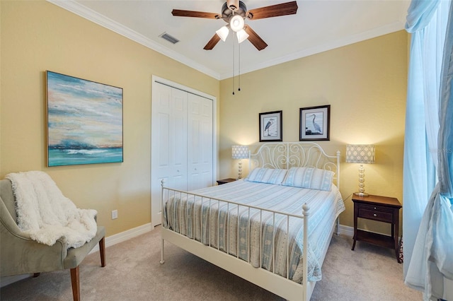 carpeted bedroom with a closet, a ceiling fan, baseboards, visible vents, and ornamental molding