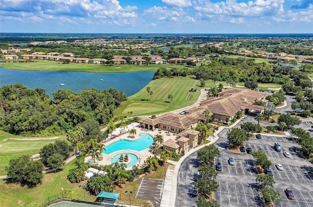 drone / aerial view with golf course view and a water view