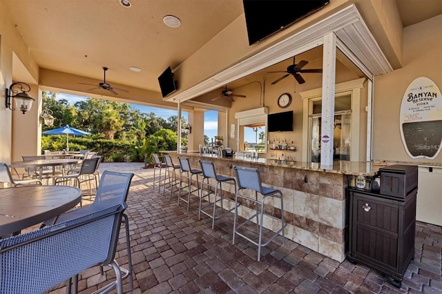 view of patio featuring a bar and ceiling fan