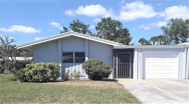 3140 Village Green Dr Unit 1119, Sarasota, FL 34239 - view of front facade featuring an attached garage, concrete driveway, stucco siding, and a front lawn