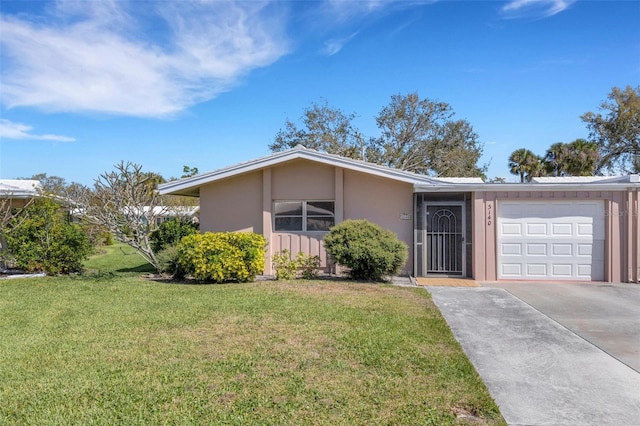3140 Village Green Dr Unit 1119, Sarasota, FL 34239 - view of front of home with an attached garage, driveway, stucco siding, and a front lawn