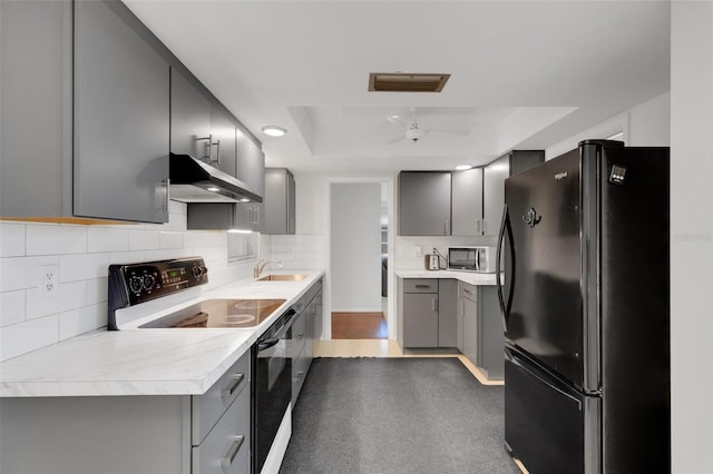 3140 Village Green Dr Unit 1119, Sarasota, FL 34239 - kitchen featuring visible vents, gray cabinets, appliances with stainless steel finishes, under cabinet range hood, and a raised ceiling