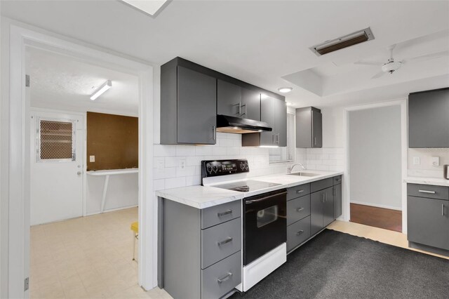 3140 Village Green Dr Unit 1119, Sarasota, FL 34239 - kitchen featuring light countertops, under cabinet range hood, visible vents, white electric range, and a sink