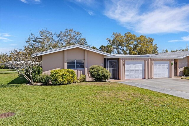 3140 Village Green Dr Unit 1119, Sarasota, FL 34239 - ranch-style house featuring a front yard, an attached garage, driveway, and stucco siding