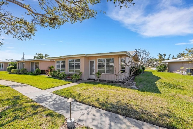 3140 Village Green Dr Unit 1119, Sarasota, FL 34239 - ranch-style home with stucco siding and a front lawn