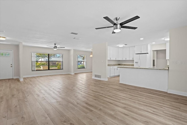 unfurnished living room featuring light wood-style flooring, baseboards, visible vents, and ceiling fan