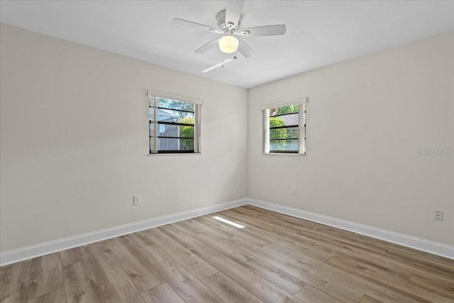 unfurnished room with ceiling fan, baseboards, and wood finished floors