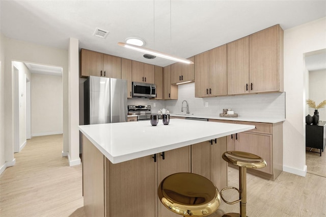6639 16th St N, Saint Petersburg, FL 33702 - kitchen with visible vents, light wood-style flooring, a sink, stainless steel appliances, and tasteful backsplash