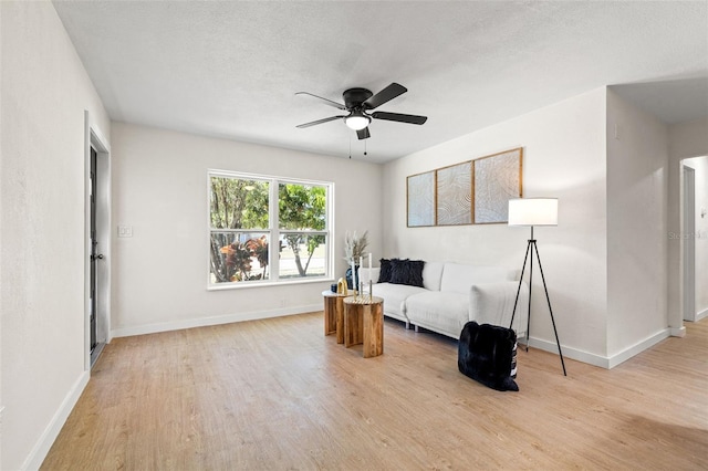 6639 16th St N, Saint Petersburg, FL 33702 - living area with ceiling fan, a textured ceiling, baseboards, and light wood-style floors