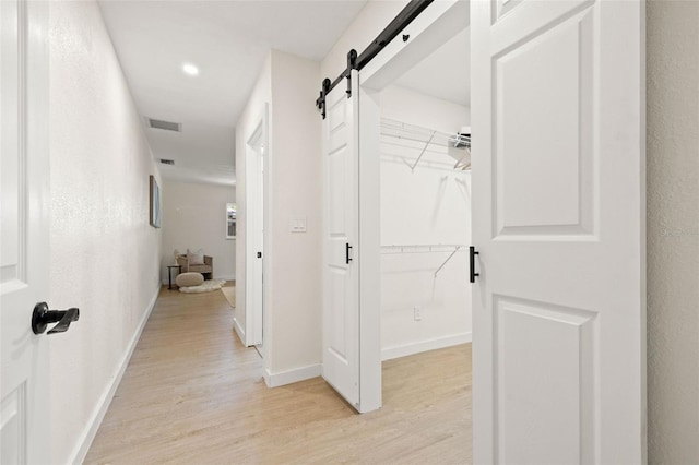 6639 16th St N, Saint Petersburg, FL 33702 - hallway with a barn door, baseboards, visible vents, and light wood finished floors