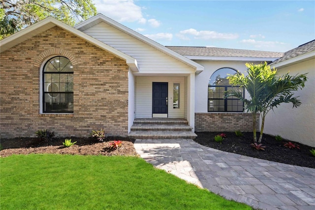 view of front of property featuring brick siding and a front yard