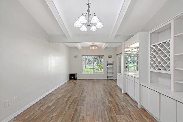 interior space featuring beamed ceiling, baseboards, light wood-style floors, and an inviting chandelier