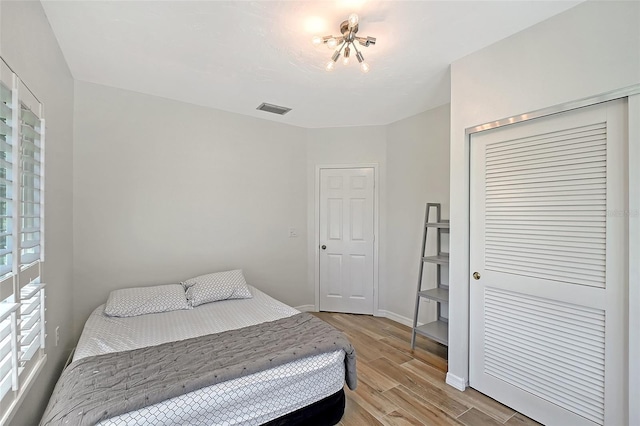 bedroom with visible vents, baseboards, a closet, and light wood finished floors