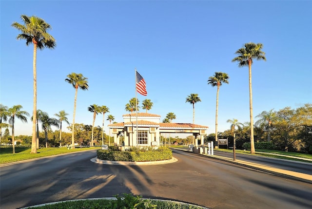 view of street featuring a gated entry and curbs