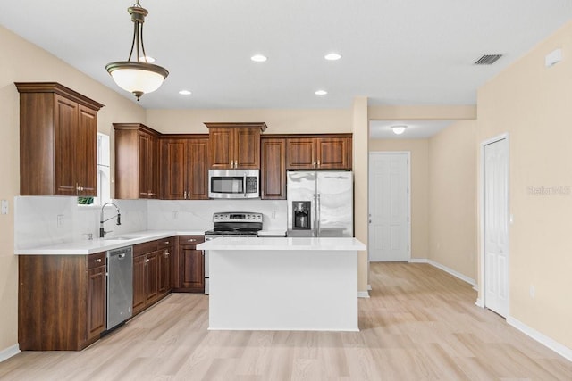 11790 Fennemore Way, Parrish, FL 34219 - kitchen with light countertops, appliances with stainless steel finishes, light wood-style flooring, and visible vents