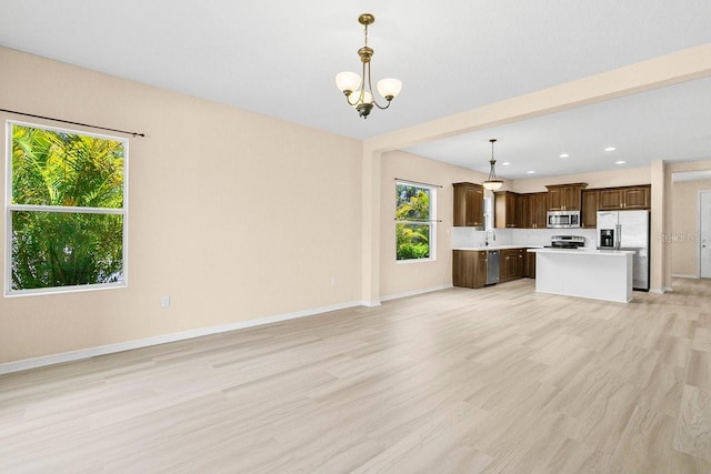 11790 Fennemore Way, Parrish, FL 34219 - unfurnished living room featuring baseboards, a notable chandelier, and plenty of natural light
