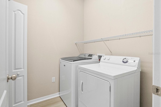 11790 Fennemore Way, Parrish, FL 34219 - clothes washing area with washing machine and clothes dryer, laundry area, baseboards, and light wood-style flooring
