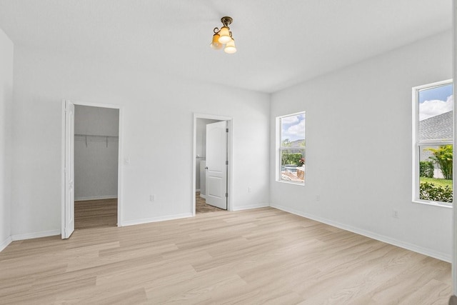 11790 Fennemore Way, Parrish, FL 34219 - unfurnished bedroom with baseboards, a spacious closet, and light wood finished floors