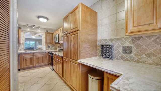5630 Golf Pointe Dr Unit 205, Sarasota, FL 34243 - kitchen featuring light tile patterned floors, tasteful backsplash, appliances with stainless steel finishes, light countertops, and a sink
