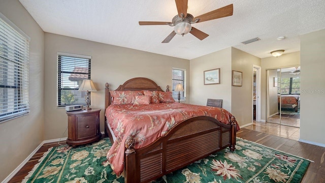 5630 Golf Pointe Dr Unit 205, Sarasota, FL 34243 - bedroom featuring a textured ceiling, wood finished floors, baseboards, and visible vents
