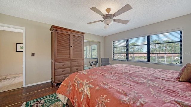 5630 Golf Pointe Dr Unit 205, Sarasota, FL 34243 - bedroom featuring ceiling fan, a textured ceiling, baseboards, and wood finished floors