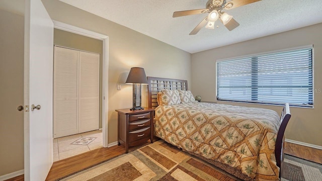 5630 Golf Pointe Dr Unit 205, Sarasota, FL 34243 - bedroom featuring a textured ceiling, wood finished floors, ceiling fan, and baseboards