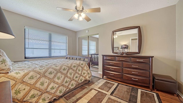 5630 Golf Pointe Dr Unit 205, Sarasota, FL 34243 - bedroom featuring a textured ceiling, a closet, wood finished floors, and ceiling fan