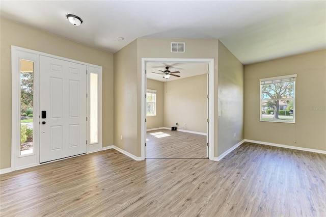 entrance foyer featuring visible vents, a ceiling fan, light wood-style floors, baseboards, and vaulted ceiling